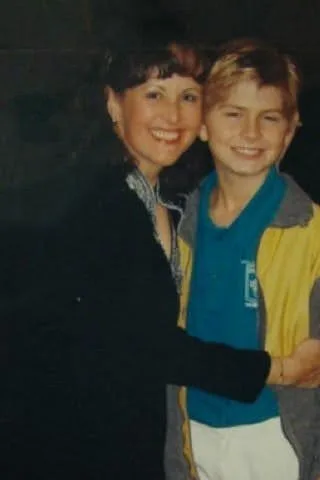David at ten, standing with his music teacher after a choir performance.